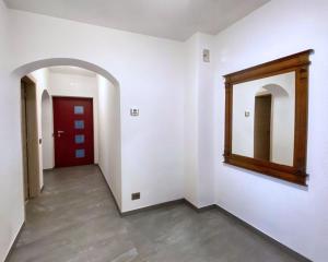 a hallway with a mirror and a red door at Casa vacanze Da Bianca in Castelfondo