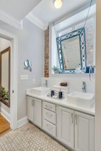 uma casa de banho com 2 lavatórios e um espelho em The Jasmine Nola em Nova Orleans