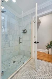 uma casa de banho com um chuveiro e uma porta de vidro em The Jasmine Nola em Nova Orleans