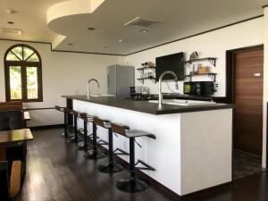 cocina con barra con taburetes y encimera en The Little Garden - Vacation STAY 58450v, en Miyazaki