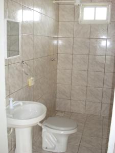 y baño con aseo y lavamanos. en Casa em Mariscal - 5 a 8 pessoas, en Bombinhas