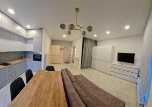 a kitchen and dining room with a wooden table at ApartPlus - Затишні апартаменти in Dnipro
