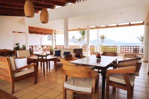 a restaurant with tables and chairs and a view of the ocean at LALORA Hotel & Villas in San Patricio Melaque