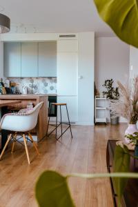 a kitchen with white cabinets and a white chair in a room at Rest In Sanok Apartment in Sanok