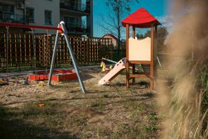 a playground with a slide and a swing set at Rest In Sanok Apartment in Sanok