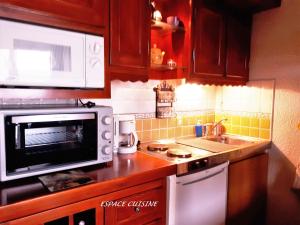 a kitchen with a microwave and a sink at Studio 2 personnes - vue Mont blanc in Saint-Gervais-les-Bains