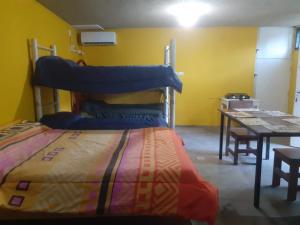 - une chambre avec des lits superposés et une table dans l'établissement Hostel el Tata, à Potrero de los Funes