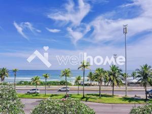 uma vista para uma praia com palmeiras e as palavras xwx home em Apto com vista para o mar na Barra da Tijuca no Rio de Janeiro