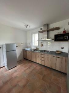 a large kitchen with a refrigerator and a stove at Rovere dalla riva in Arzene