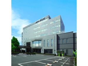 un grand bâtiment avec un parking devant dans l'établissement Hotel Montagne Matsumoto - Vacation STAY 73657v, à Matsumoto
