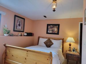 a bedroom with a bed with a wooden headboard at Charming - 2 bedrooms basemnt, 1 full bath & rec room in Kamloops
