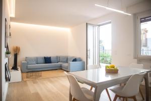 un soggiorno con tavolo e divano blu di Appartamento Elise a Siderno Marina