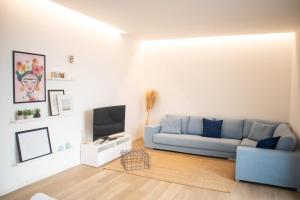 un soggiorno con divano blu e TV di Appartamento Elise a Siderno Marina