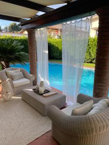 eine Terrasse mit 2 Sofas und einem Pool in der Unterkunft Your house by the sea in Marina di Pietrasanta