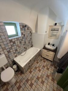 a bathroom with a tub and a toilet and a sink at Pannonhalma Várlak Vendégház Demeter Lak in Pannonhalma