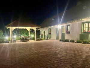 a house with a brick patio at night at Pannonhalma Várlak Vendégház Demeter Lak in Pannonhalma