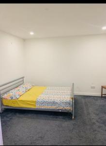 ein Schlafzimmer mit einem Bett mit einer gelben Decke in der Unterkunft Sam’s House in Purley