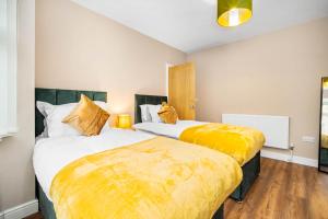 2 Betten in einem Hotelzimmer mit gelber Bettwäsche in der Unterkunft 3 bed house for Contractors & Families /Sleeps 5/Driveway parking 2 cars in Oldbury