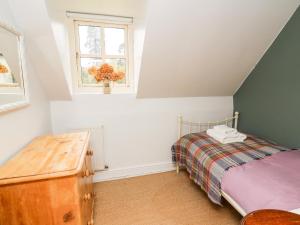 a bedroom with a bed and a window at Otters Holt in Llandeilo