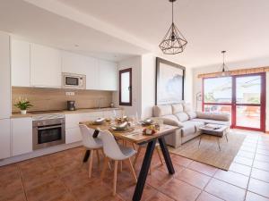 cocina y sala de estar con mesa y sofá en Giraud II - Secluded beachfront duplex, en Santa María de Guía de Gran Canaria