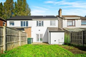 ein Haus mit einem Zaun und einer weißen Garage in der Unterkunft 3 bed house for Contractors & Families /Sleeps 5/Driveway parking 2 cars in Oldbury