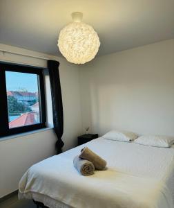 sypialnia z 2 łóżkami i żyrandolem w obiekcie Liège Luxe & Jacuzzi sous les étoiles w mieście Saint-Nicolas
