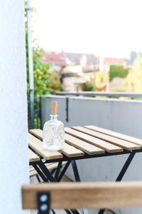 - une bouteille assise sur une table de pique-nique sur un balcon dans l'établissement Moderne 3-Zimmer-Wohnung in Top-Lage, à Karlsruhe
