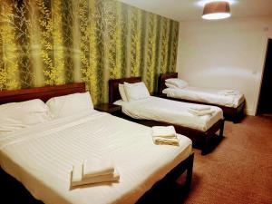 a hotel room with two beds with towels on them at The Gillygate Bar and Rooms in York