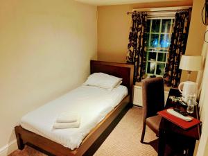 a bedroom with a bed and a desk and a window at The Gillygate Bar and Rooms in York