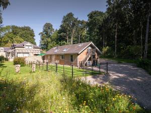 The Old Workshop, Corbridge في كوربريدج: منزل خشبي أمامه سور