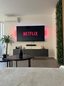 einen TV an einer Wand mit einem Netflix-Schild drauf in der Unterkunft Liège Luxe & Jacuzzi sous les étoiles in Saint-Nicolas