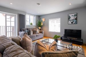 a living room with a couch and a tv at Modern Luxury Apartment In The Heart of Henley in Henley on Thames