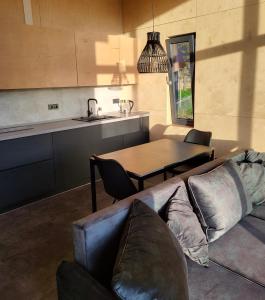 ein Wohnzimmer mit einem Sofa und einem Tisch sowie eine Küche in der Unterkunft CloudBase in Tukhlya