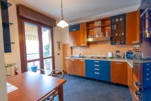 a kitchen with wooden cabinets and a table and a counter at monica Casa Vacanza in Busto Arsizio