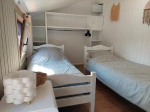 two beds in a small room with a table at Maison à Portiragnes Plage - Résidence les Tamaris - Porte du Soleil - Prix piscine comprise in Portiragnes +35 photos