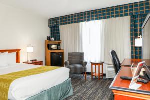 Pokój hotelowy z łóżkiem i biurkiem w obiekcie Ramada by Wyndham Cumberland Downtown w mieście Cumberland