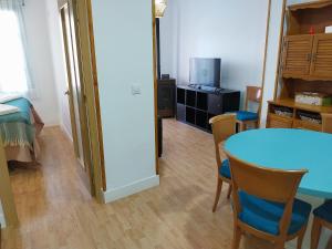 a room with a table and chairs and a television at Apartamento San Juan in Riaza