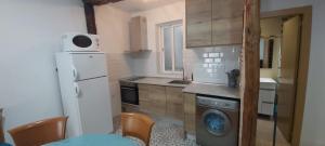 a kitchen with a refrigerator and a washing machine at Apartamento San Juan in Riaza