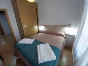 ein Schlafzimmer mit einem Bett mit zwei Handtüchern darauf in der Unterkunft Apartamento San Juan in Riaza