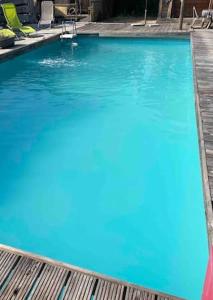a large swimming pool with blue water and chairs at LES CHALETS DE VANESS' l'Eden in Digoin +2 photos