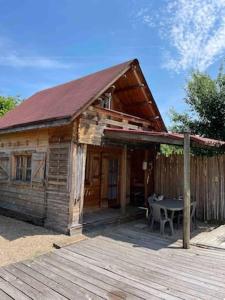 a small wooden house with a table in front of it at LES CHALETS DE VANESS' l'Eden in Digoin