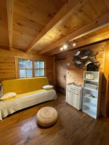 a room with a couch in a wooden cabin at LES CHALETS DE VANESS' l'Eden in Digoin