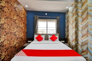 a bedroom with a large bed with red pillows at OYO Flagship Hotel 7 Star in Udaipur