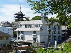 een wit gebouw met een pagode op de achtergrond bij ＨＯＴＥＬ ＰＡＧＯＤＡ - Vacation STAY 65048v in Nara
