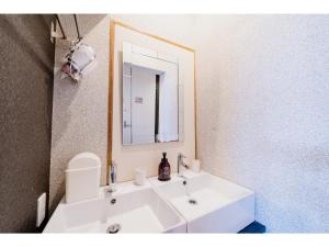 een badkamer met een witte wastafel en een spiegel bij ＨＯＴＥＬ ＰＡＧＯＤＡ - Vacation STAY 65048v in Nara