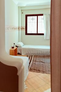 een kamer met 2 bedden en een raam bij DesArt in Tamraght Ouzdar