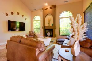 a living room with leather furniture and a fireplace at Sedona Getaway with Sunlit Patio Near Bell Rock! in Sedona