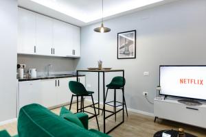 sala de estar con sofá verde y TV en Luxurious Suite near New Bazaar, en Tirana
