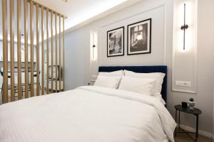 1 dormitorio con 1 cama blanca grande y cabecero azul en Luxurious Suite near New Bazaar, en Tirana