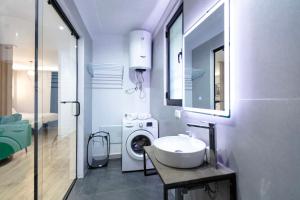 y baño con lavabo y lavadora. en Luxurious Suite near New Bazaar, en Tirana